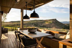 Wooden terrace featuring a mountain view and outdoor dining area