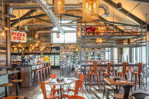 Dining area featuring a towering ceiling, a dry bar, and hardwood / wood-style flooring