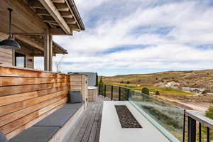 Wooden deck featuring an outdoor fire pit and a mountain view