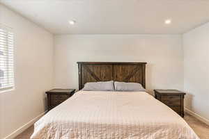 Bedroom with multiple windows, baseboards, carpet flooring, and recessed lighting