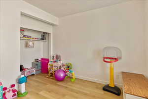 Playroom with baseboards and wood finished floors