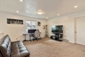 Office space featuring baseboards, visible vents, a textured ceiling, carpet flooring, and recessed lighting