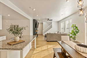 Living area featuring a ceiling fan, stairs, a textured ceiling, light wood-style floors, and recessed lighting