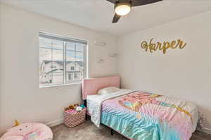 Carpeted bedroom featuring a ceiling fan and baseboards