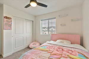 Bedroom with ceiling fan, carpet floors, and a closet