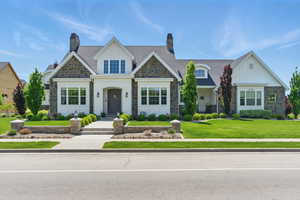 View of front of home featuring stone siding, board and batten siding, and a front yard