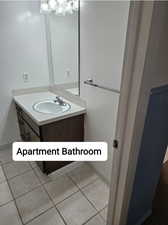 Bathroom with vanity, baseboards, and tile patterned floors