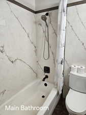 Full bathroom with toilet and shower / bathtub combination with curtain