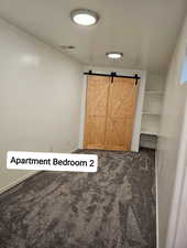 Interior space featuring a barn door, visible vents, and baseboards