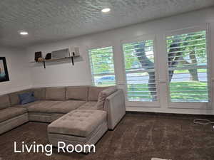 Living room with recessed lighting, carpet flooring, and a textured ceiling