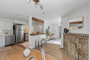 Kitchen with visible vents, white cabinets, appliances with stainless steel finishes, backsplash, and light wood finished floors