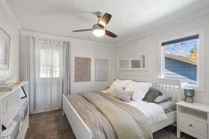 Bedroom featuring carpet floors, a ceiling fan, and crown molding