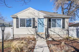 Bungalow with entry steps, fence, and roof with shingles