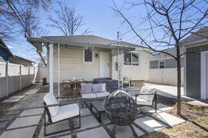 Rear view of property featuring a patio, a shingled roof, and a fenced backyard