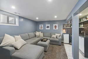 Living area with light tile patterned floors, beverage cooler, visible vents, indoor wet bar, and recessed lighting