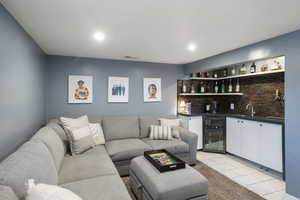 Living area with beverage cooler, visible vents, light tile patterned flooring, indoor wet bar, and recessed lighting