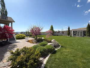 View of yard with an outdoor structure, a patio area, and fence