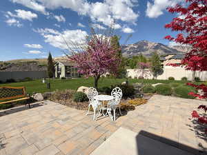 View of patio with an outdoor structure, fence, and a mountain view