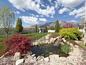 Property view of mountains featuring a garden pond