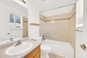Full bathroom with tub / shower combination, vanity, toilet, and tile patterned floors