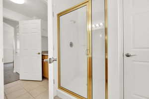 Bathroom with tile patterned flooring and a shower stall