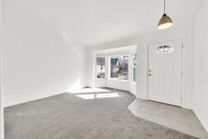 Foyer with carpet floors, tile patterned flooring, and baseboards