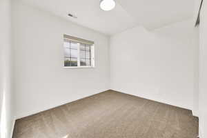 Spare room with carpet floors, visible vents, and baseboards
