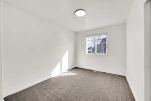 Carpeted empty room featuring visible vents and baseboards