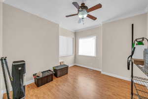 Misc room with ornamental molding, a ceiling fan, a textured ceiling, wood finished floors, and baseboards