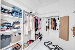 Walk in closet with attic access and tile patterned floors