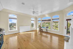Living room with wood-type flooring, baseboards, and ceiling fan