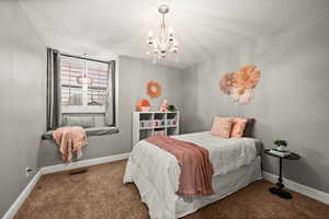 Carpeted bedroom with an inviting chandelier, visible vents, baseboards, and a textured ceiling