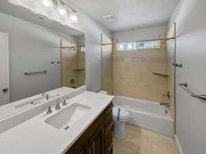 Bathroom featuring toilet, tile patterned flooring, shower / tub combination, and visible vents