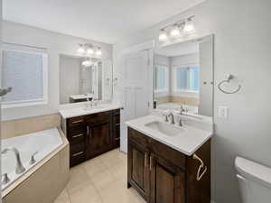 Bathroom with a garden tub, two vanities, a sink, and visible vents