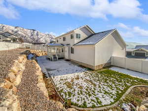 Rear view of property featuring a patio, a fenced backyard, a mountain view, and stucco siding