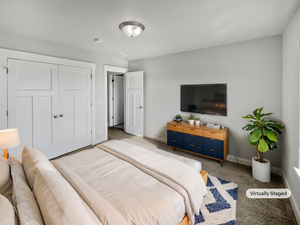 Carpeted bedroom featuring a closet and baseboards