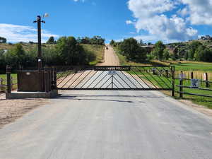 View of gate featuring a lawn