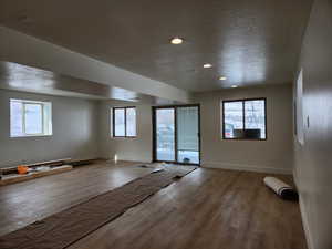 Interior space featuring a textured ceiling, wood finished floors, and a healthy amount of sunlight