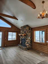 Unfurnished living room featuring a wealth of natural light, a fireplace, a textured ceiling, and wood finished floors