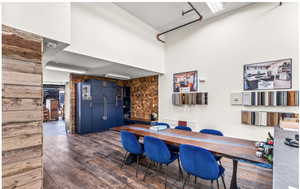 Dining space featuring dark wood-style floors and a high ceiling