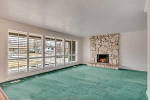 Living room with baseboards, a fireplace, carpet flooring, and crown molding