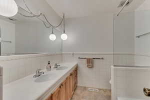 Hall bathroom with vanity, tile flooring, and a double sink