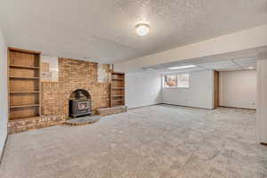 Family room with a wood stove, new carpet, and a textured ceiling. Outside entrance