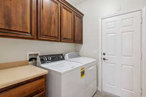 Laundry area featuring cabinet space and washing machine and dryer