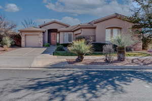 Mediterranean / spanish home featuring an attached garage, a tile roof, stone siding, concrete driveway, and stucco siding