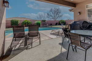 View of patio with a fenced backyard, a grill, and a fenced in pool