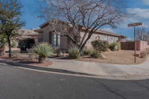 View of front of house featuring concrete driveway, fence, and stucco siding