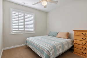 Bedroom with ceiling fan, carpet flooring, visible vents, and baseboards