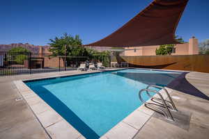 Community pool featuring a patio area, fence, and a mountain view