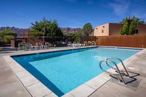 Pool featuring a mountain view, a patio area, and fence